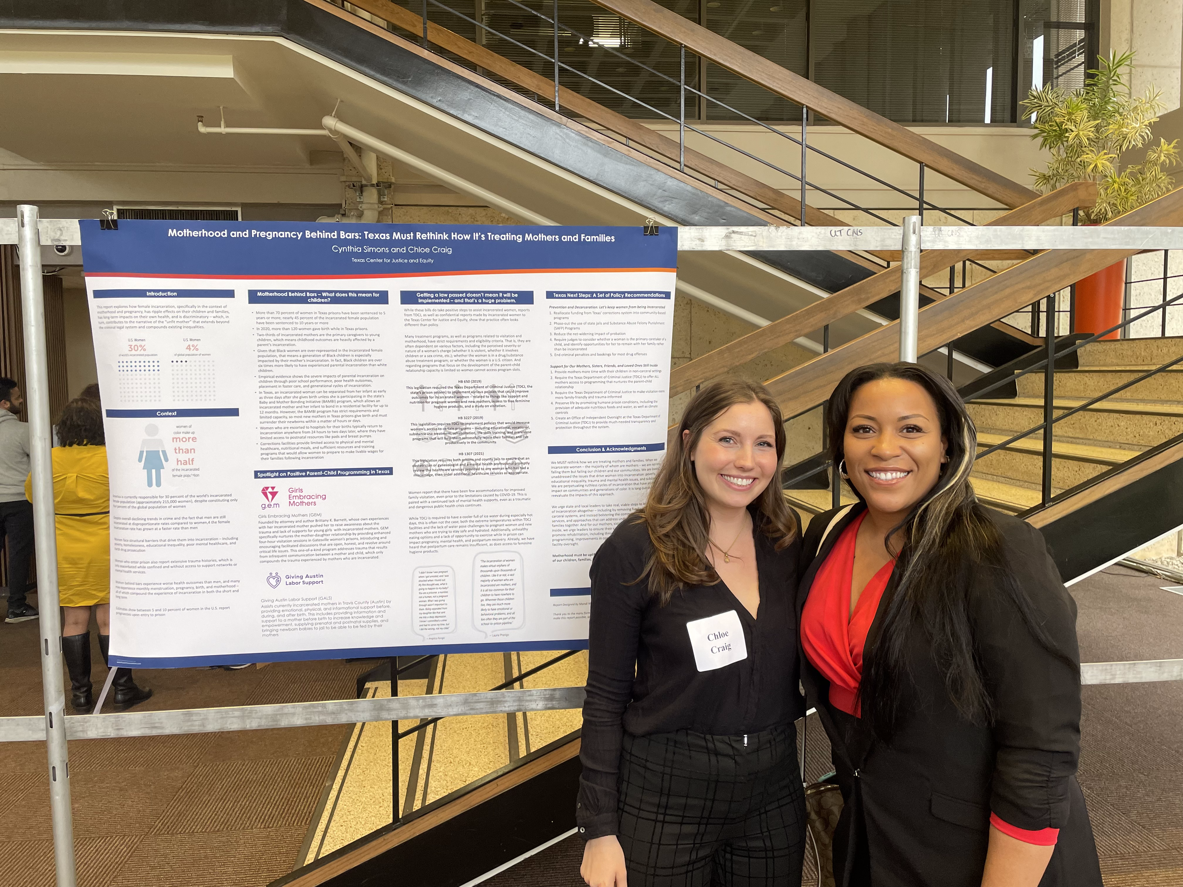 Cynthia and Chloe pose with a presentation of their report