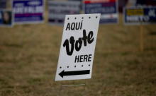 Sign at polling place reading Aqui Vote Here