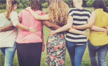 Women facing away from camera with their arms around each other