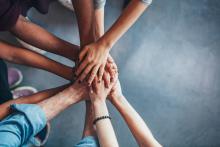 People's hands stacked on top of each other in a circle