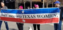 People marching with a poster reading: don't mess with Texas women